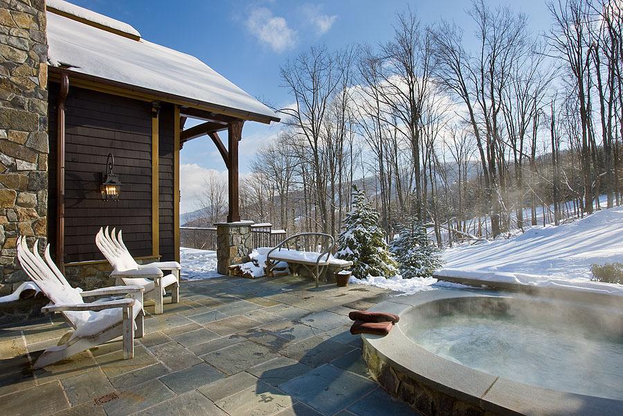 Exterior, horizontal, rear patio with built in hot tub looking out to ski slope and mountain, Schimel residence, Windham, New York; Woodhouse Post & Beam