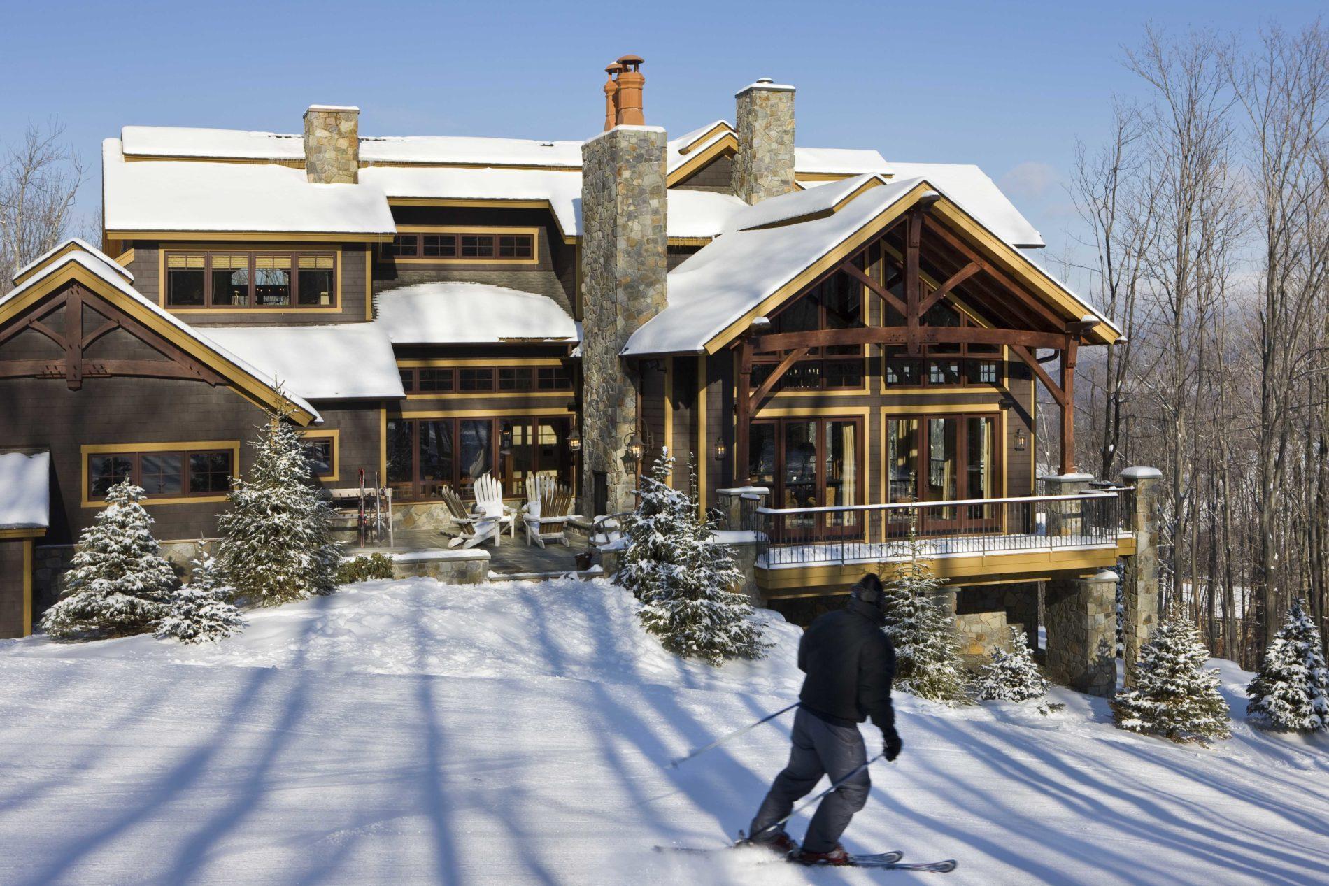 Exterior, horizontal, south elevation from ski slope with skier in foreground, Schimel residence, Windham, New York; Woodhouse Post &amp; Beam