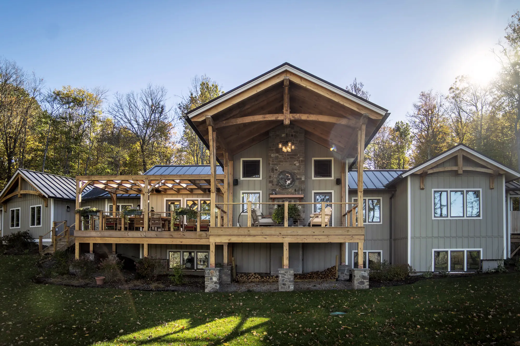 An exterior of a timber frame, single story house. The back porche is framed in timber.
