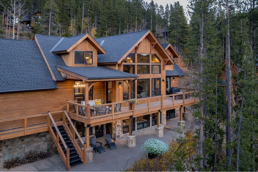 Spacious timber frame mountain home with expansive deck and large window wall overlooking forested terrain, suited for Eagle Rock Resort properties.