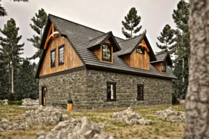 Rear exterior of the Shelburne V2 timber frame carriage house showing stone walls, wood siding, decorative gable details, and upper-level windows in a wooded setting.