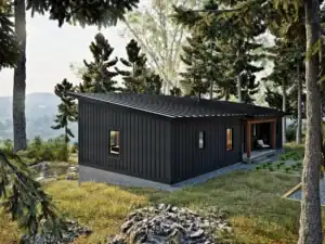 Rear view of the RiverRock V2 modern timber frame home showing the low-slope roof, dark vertical siding, and wooded setting overlooking the landscape.