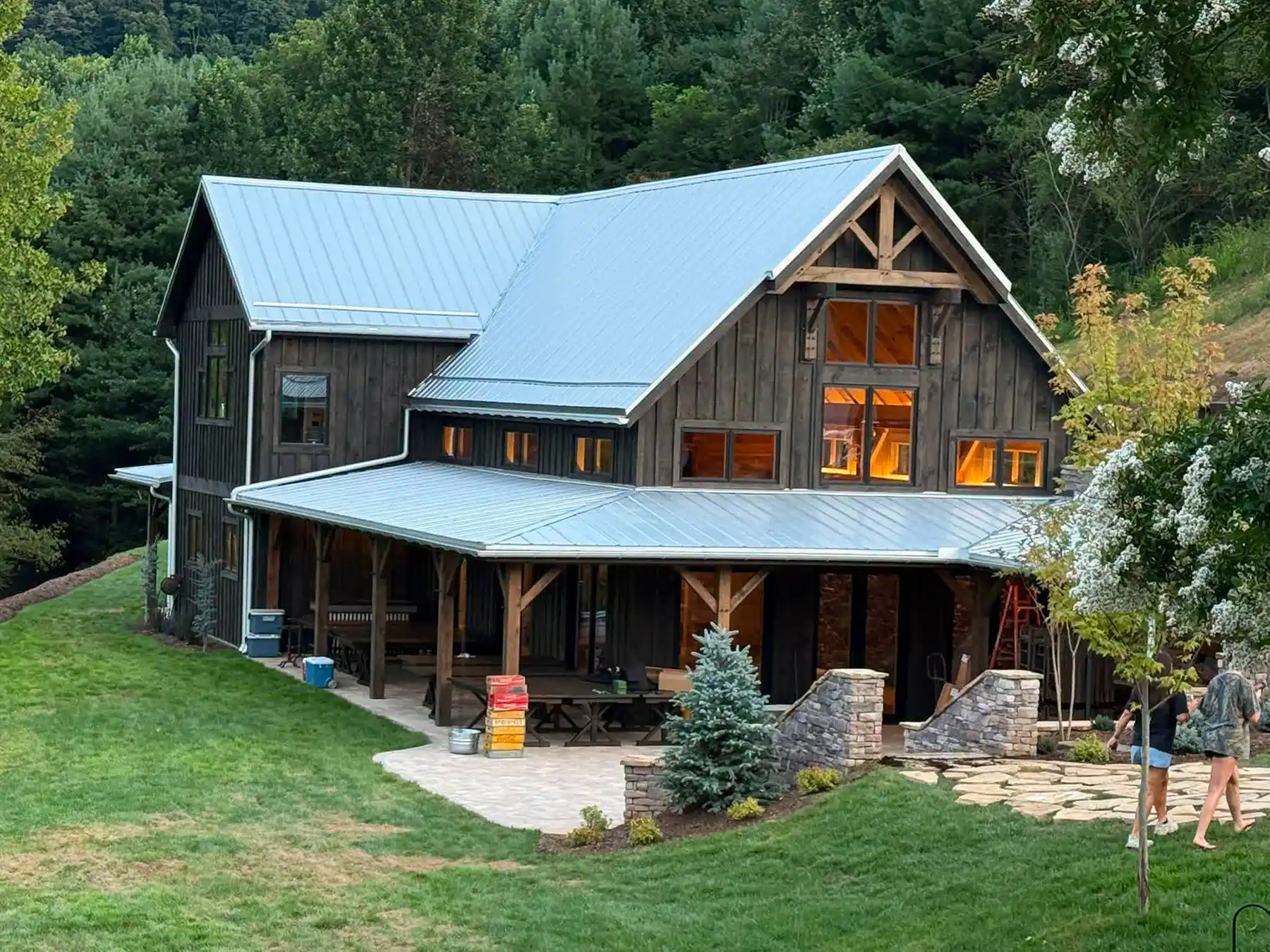Exterior view of the Oak & Vine Event Center with exposed timber details, dark wood siding, metal roofing, and landscaped grounds.
